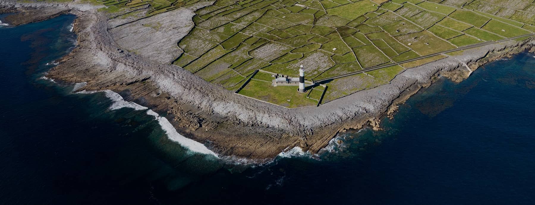 Aerial shot of Inisheer Lighthouse overlooking the ocean on the Aran Islands